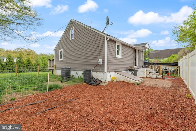 back of property featuring fence and central air condition unit
