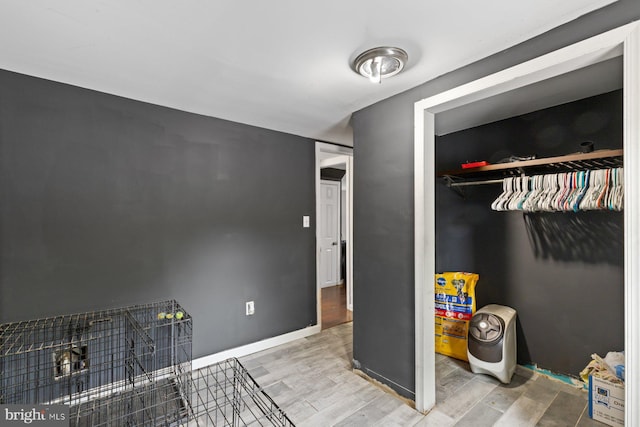 bedroom featuring wood finished floors, a closet, and baseboards