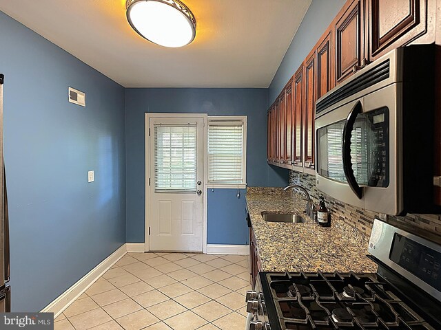 1206 Cedarcroft Rd, Baltimore, MD 21239 - kitchen with appliances with stainless steel finishes, a sink, light tile patterned floors, baseboards, and light stone countertops