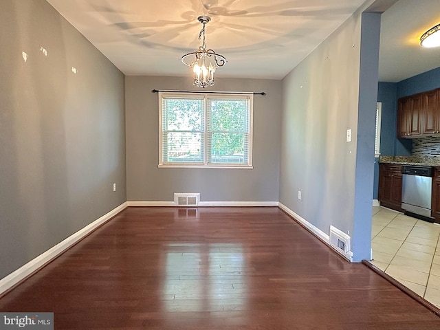 1206 Cedarcroft Rd, Baltimore, MD 21239 - unfurnished dining area featuring a chandelier, light wood-style flooring, and baseboards