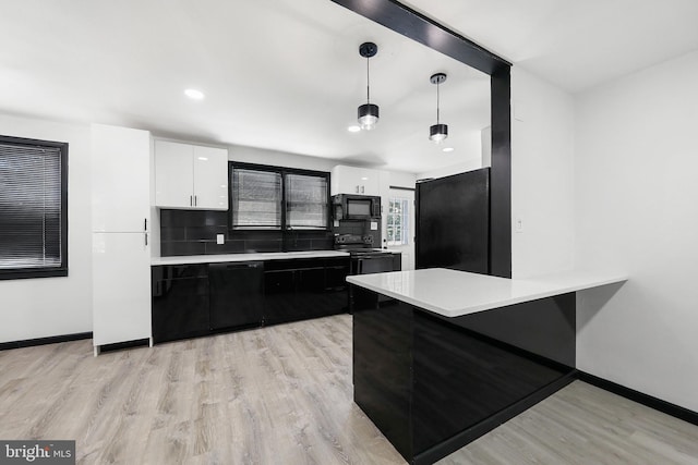 kitchen with black appliances, white cabinets, light countertops, light wood-style flooring, and recessed lighting