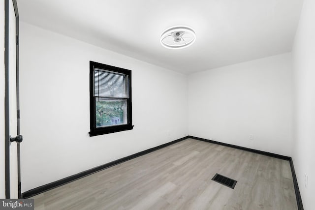 spare room with wood finished floors and baseboards