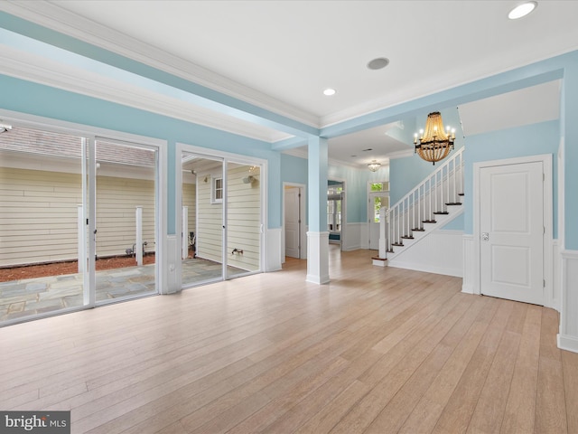 27173 Barefoot Blvd Unit 15, Millsboro, DE 19966 - unfurnished living room featuring a chandelier, stairs, light wood-style floors, wainscoting, and ornamental molding