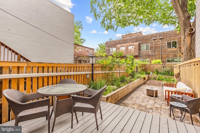 wooden terrace featuring fence, outdoor dining area, and a patio area
