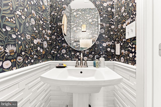 bathroom with wallpapered walls and a wainscoted wall