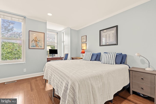 bedroom with baseboards, wood finished floors, recessed lighting, and ornamental molding
