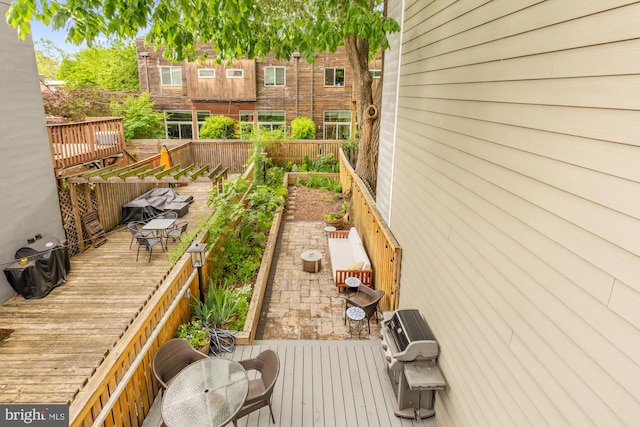 fenced backyard featuring a wooden deck, a vegetable garden, and outdoor dining space