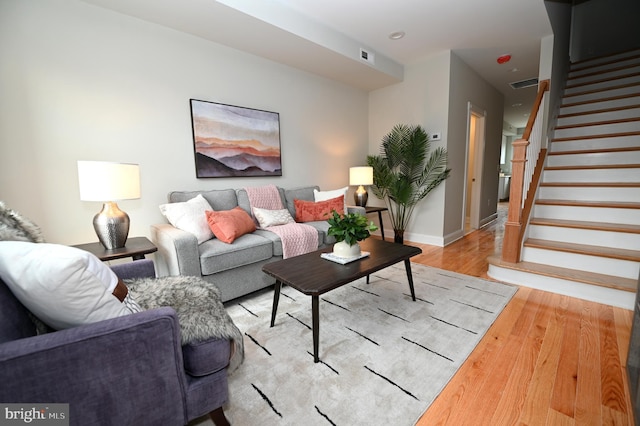 living area with light wood-style floors, stairs, baseboards, and recessed lighting
