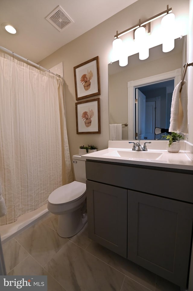 bathroom featuring toilet, vanity, and a shower with curtain