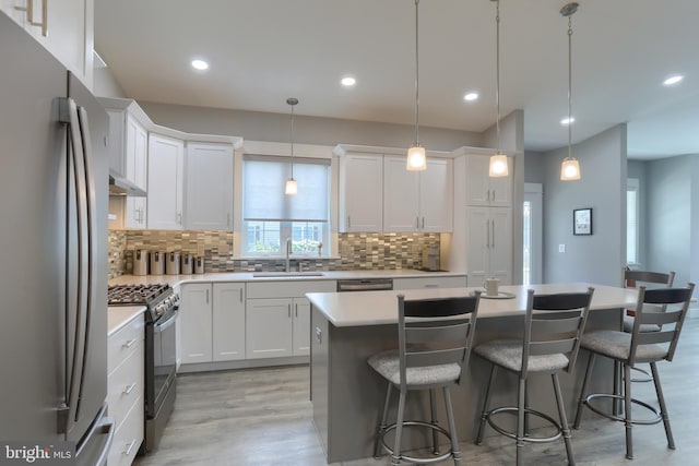 82 S Village Cir Unit 238, Palmyra, PA 17078 - kitchen featuring stainless steel appliances, a sink, a kitchen island, light wood-style flooring, and decorative backsplash