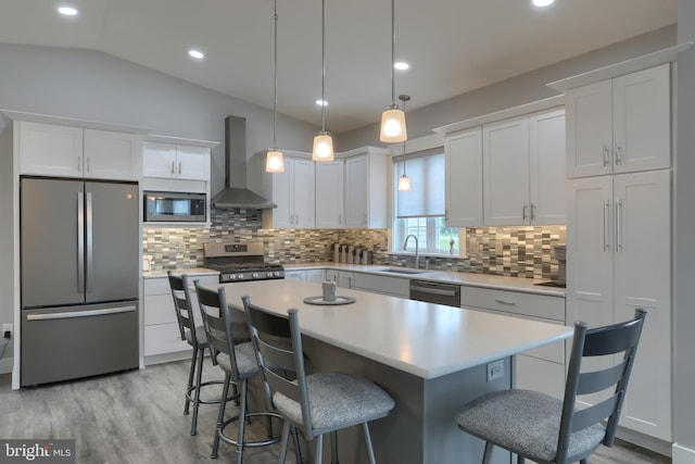 82 S Village Cir Unit 238, Palmyra, PA 17078 - kitchen with appliances with stainless steel finishes, wall chimney exhaust hood, white cabinets, light countertops, and a kitchen bar