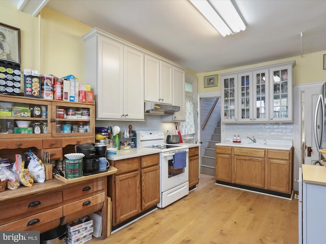 214 Center St, Edinburg, VA 22824 - kitchen with electric stove, under cabinet range hood, light countertops, light wood finished floors, and backsplash