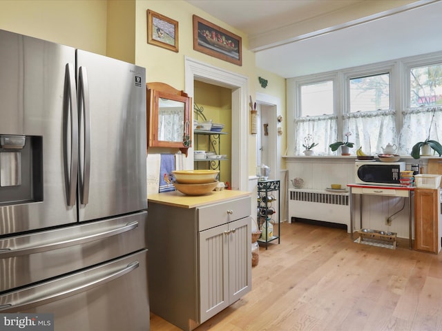 214 Center St, Edinburg, VA 22824 - kitchen featuring stainless steel fridge with ice dispenser, radiator, light wood-style flooring, and healthy amount of natural light