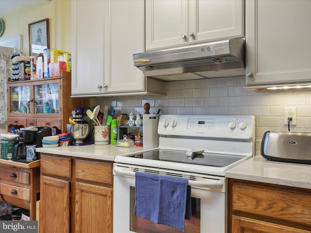 214 Center St, Edinburg, VA 22824 - kitchen featuring white electric range oven, under cabinet range hood, light countertops, and backsplash