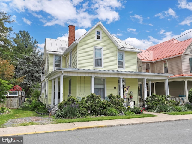 214 Center St, Edinburg, VA 22824 - farmhouse featuring a standing seam roof, a chimney, a porch, metal roof, and fence