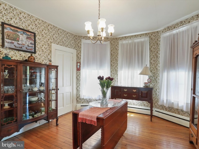 214 Center St, Edinburg, VA 22824 - dining space featuring wallpapered walls, a chandelier, wood-type flooring, and a baseboard heating unit
