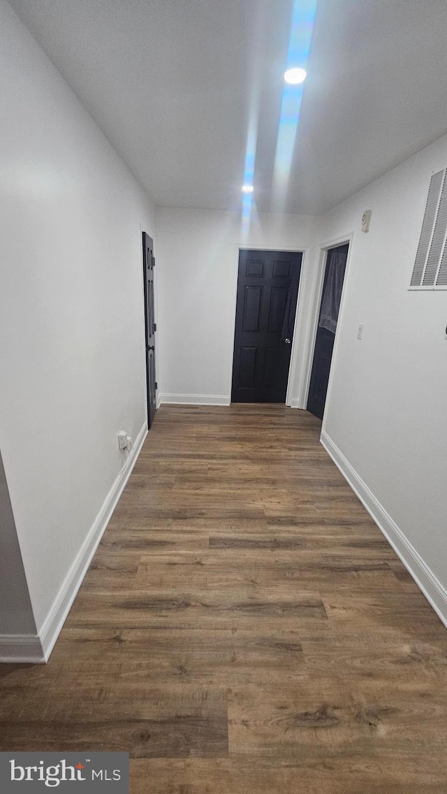 corridor with baseboards and dark wood finished floors