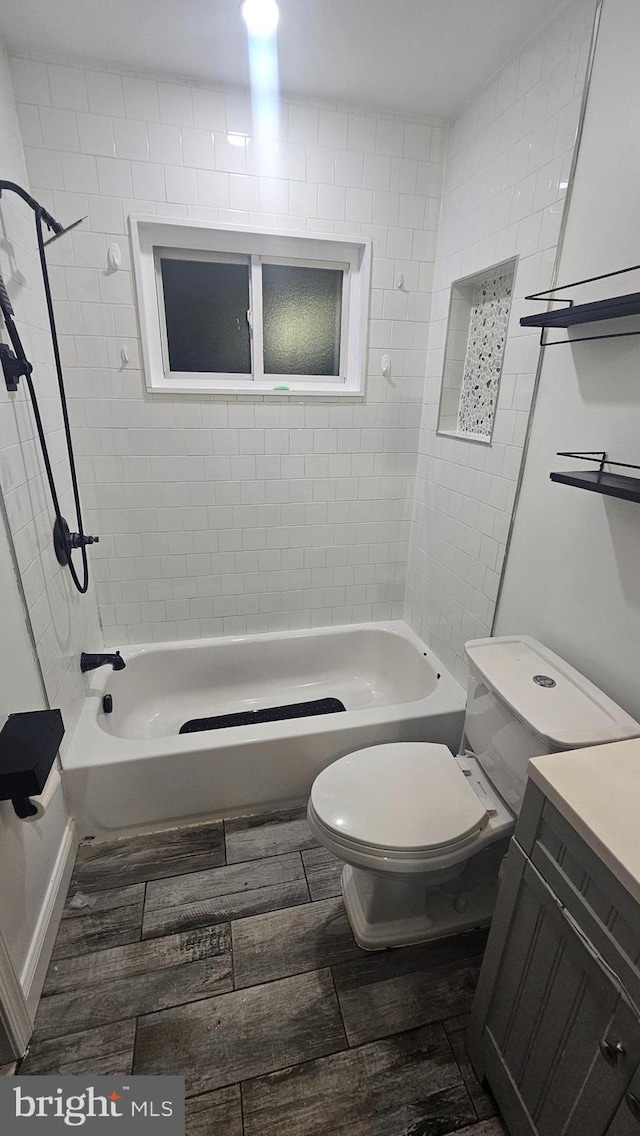 full bath featuring toilet, wood finished floors, shower / tub combination, and vanity