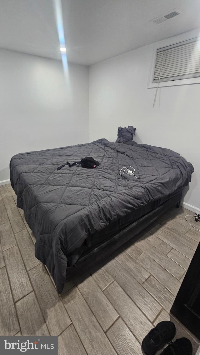 bedroom with wood finished floors and baseboards