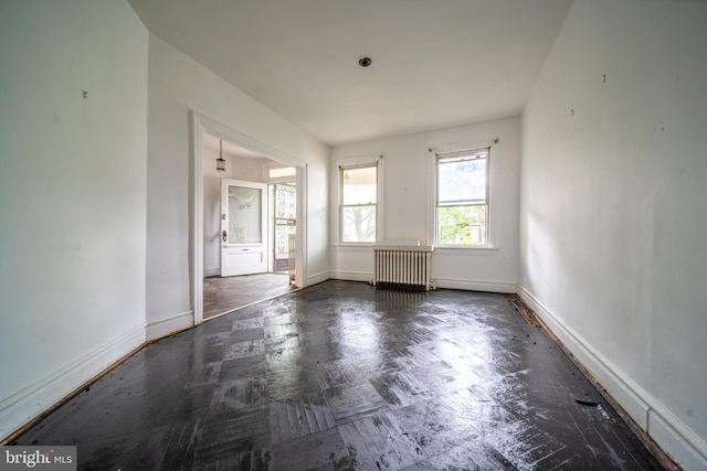 unfurnished room with radiator and baseboards