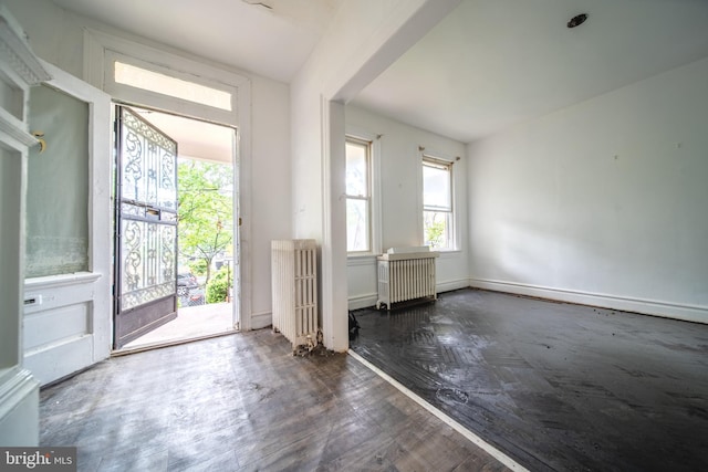 entrance foyer with wood finished floors and radiator heating unit