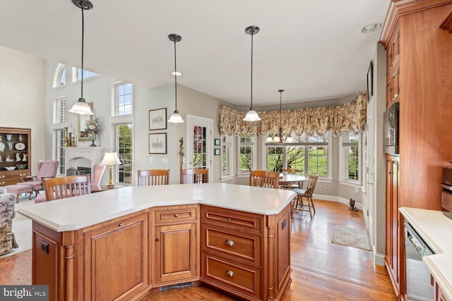 kitchen with healthy amount of natural light, light countertops, dishwasher, and brown cabinetry