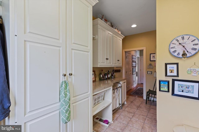 kitchen featuring white cabinetry, recessed lighting, baseboards, light tile patterned floors, and light stone countertops