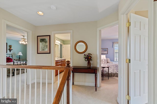 hall with light colored carpet and baseboards
