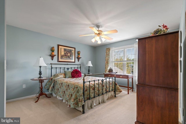 bedroom with light carpet, baseboards, and a ceiling fan