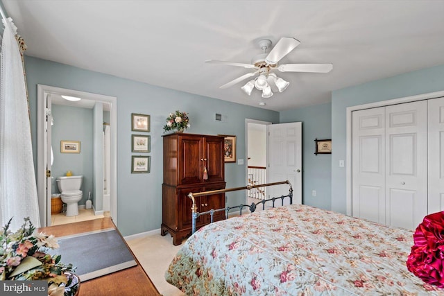 bedroom with light carpet, a closet, ceiling fan, ensuite bathroom, and baseboards