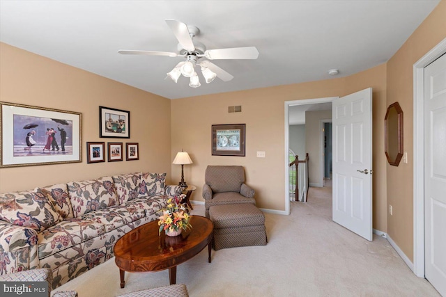 living room featuring light colored carpet, a ceiling fan, and baseboards