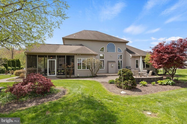 back of house featuring a patio area, a sunroom, and a yard