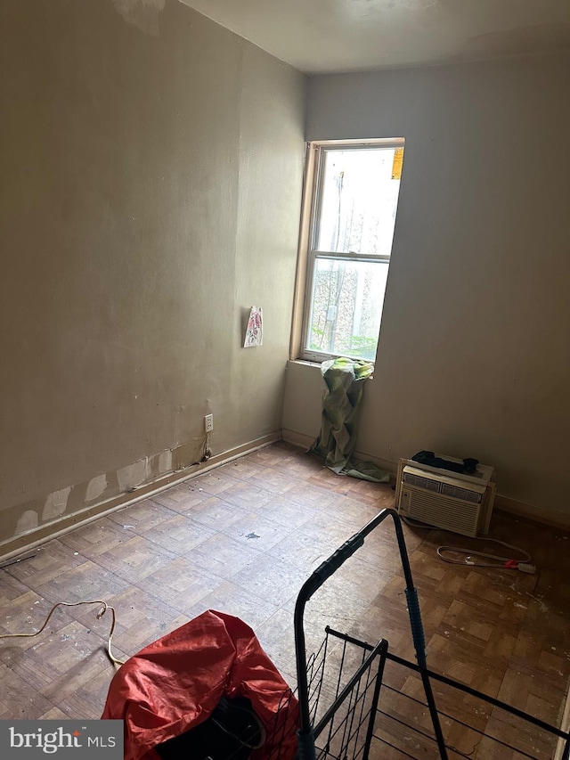 unfurnished room featuring an AC wall unit