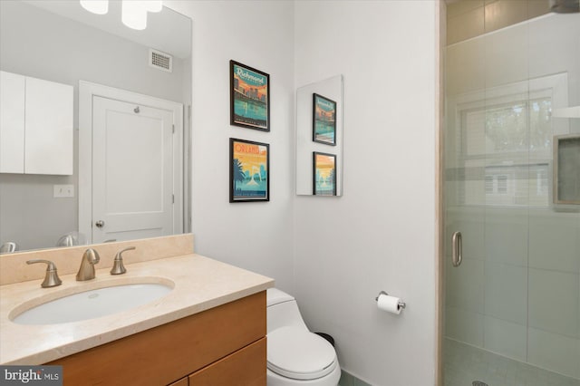 full bathroom with a shower stall, toilet, and vanity