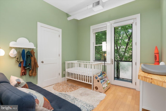 bedroom featuring light wood finished floors and access to exterior