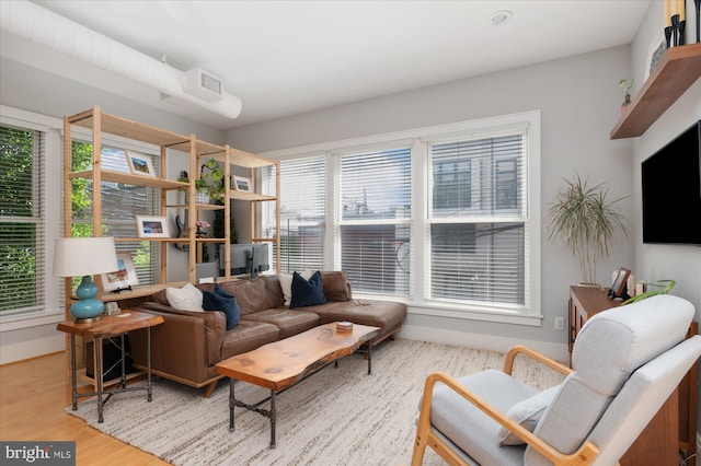 living room with healthy amount of natural light, wood finished floors, and baseboards
