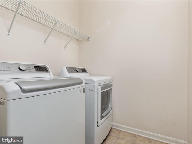 9411 Zebedee St, Manassas, VA 20110 - laundry area featuring separate washer and dryer, baseboards, and light tile patterned floors