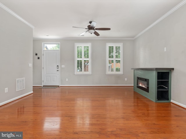 9411 Zebedee St, Manassas, VA 20110 - unfurnished living room with crown molding, ceiling fan, wood finished floors, a glass covered fireplace, and baseboards