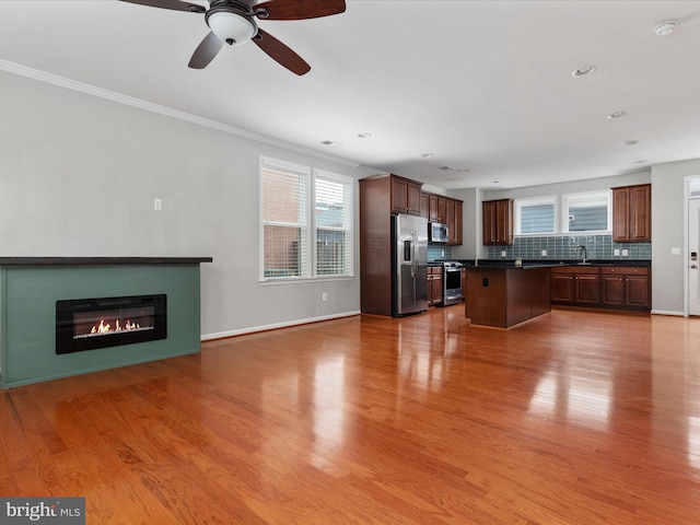 9411 Zebedee St, Manassas, VA 20110 - unfurnished living room featuring a sink, a glass covered fireplace, ornamental molding, light wood finished floors, and a ceiling fan