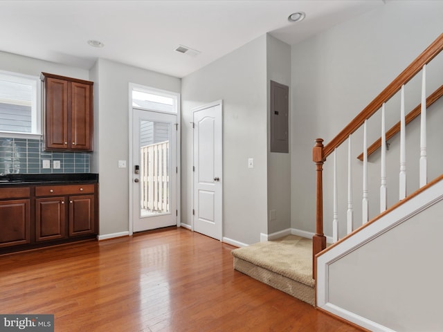 9411 Zebedee St, Manassas, VA 20110 - entrance foyer with electric panel, light wood-style flooring, baseboards, and stairs