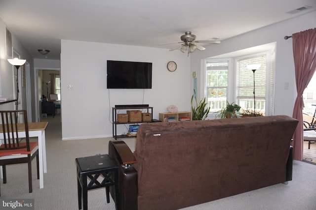 living area featuring carpet floors, ceiling fan, and baseboards