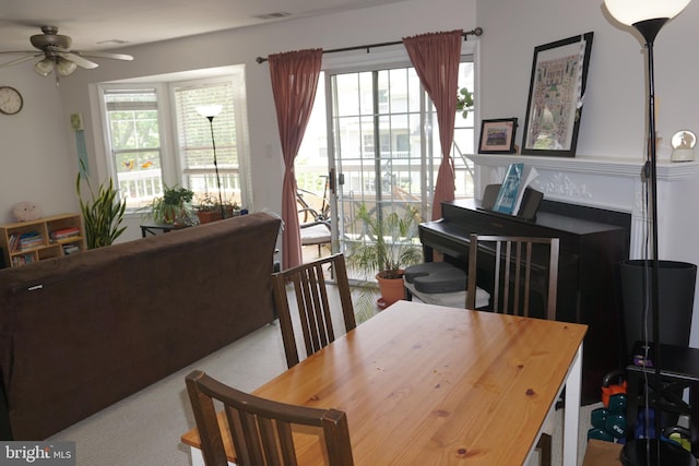 dining area featuring a ceiling fan, healthy amount of natural light, and carpet