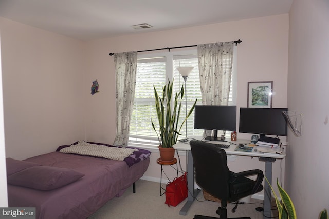 carpeted bedroom featuring a desk and baseboards