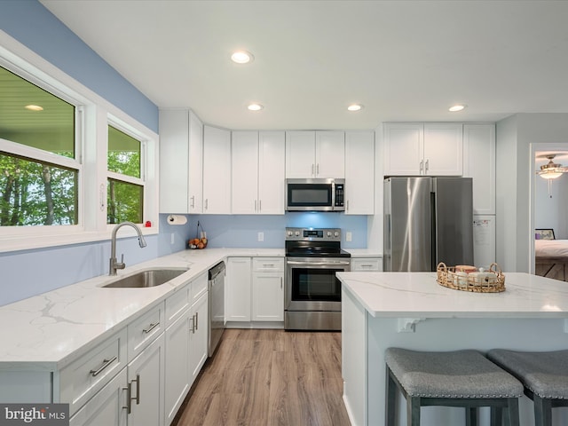 433 Tulip Poplar Dr, Linden, VA 22642 - kitchen featuring appliances with stainless steel finishes, a sink, light stone countertops, white cabinetry, and light wood-style floors