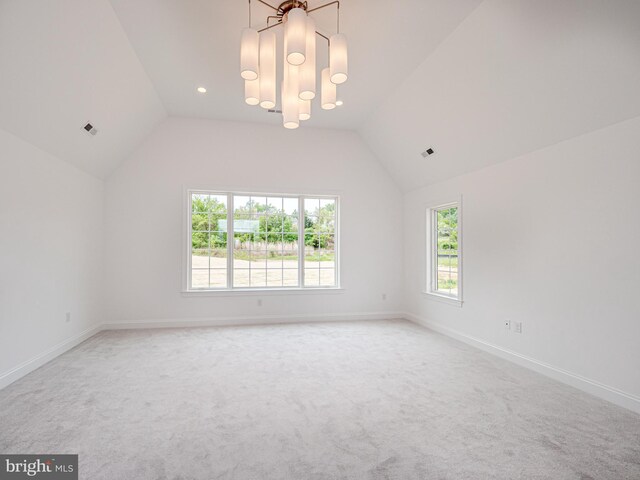 unfurnished room featuring vaulted ceiling, light carpet, baseboards, and a chandelier