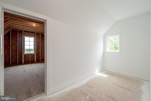 bonus room featuring vaulted ceiling, plenty of natural light, and baseboards