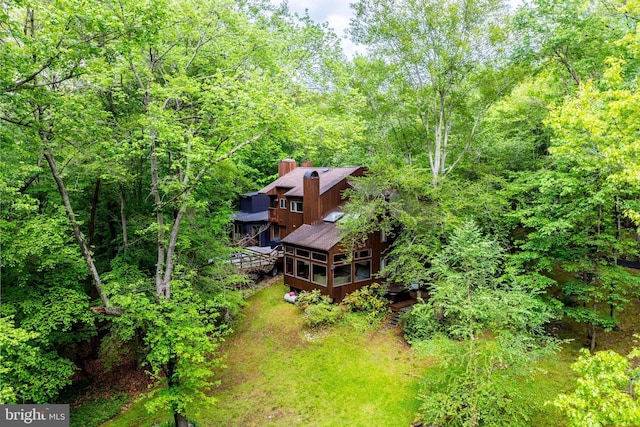 aerial view of property and surrounding area featuring a heavily wooded area