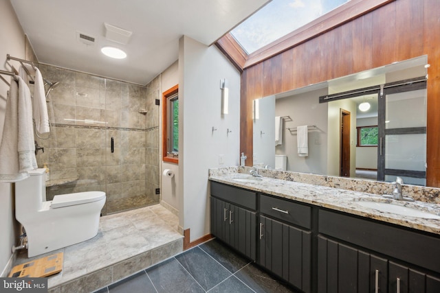 bathroom featuring toilet, a stall shower, a skylight, tile patterned flooring, and double vanity