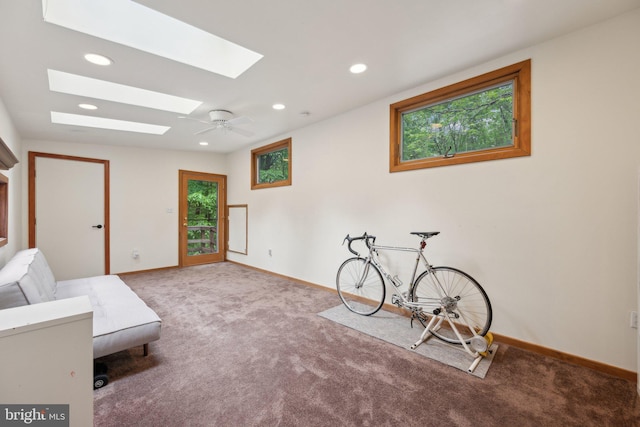 unfurnished room featuring a skylight, carpet floors, baseboards, and recessed lighting