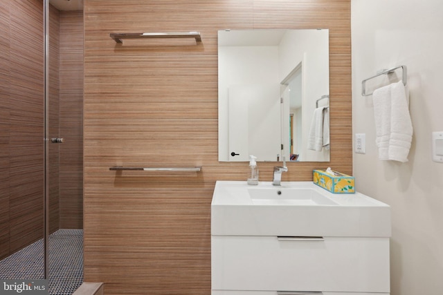 full bathroom featuring a tile shower and vanity
